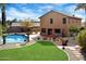 Back exterior view of a home with a covered patio, swimming pool, and desert landscaping at 23225 N 23Rd Pl, Phoenix, AZ 85024