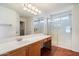 A well-lit bathroom featuring a shower, vanity with a sink, and a closet at 23225 N 23Rd Pl, Phoenix, AZ 85024