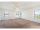 A bright bedroom featuring three windows and carpeted floors at 23225 N 23Rd Pl, Phoenix, AZ 85024