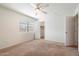 A carpeted bedroom with a ceiling fan and an open closet at 23225 N 23Rd Pl, Phoenix, AZ 85024