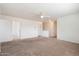 A carpeted bonus room featuring a ceiling fan and access to other rooms at 23225 N 23Rd Pl, Phoenix, AZ 85024