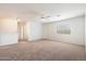 An airy carpeted bonus room features a ceiling fan and a large window at 23225 N 23Rd Pl, Phoenix, AZ 85024