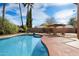 A backyard pool with a nearby seating area and desert landscaping at 23225 N 23Rd Pl, Phoenix, AZ 85024