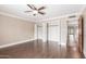 Empty bedroom with hardwood floors, ceiling fan, and a doorway that leads to a hallway at 2510 E Crittenden Ln, Phoenix, AZ 85016