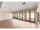 Spacious living room featuring hardwood floors and a wall of French doors to the outdoor space at 2510 E Crittenden Ln, Phoenix, AZ 85016