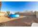 Backyard showcasing a blue inflatable pool, swing set, and trampoline, enclosed by a tall block wall at 25913 W Cat Balue Dr, Buckeye, AZ 85396