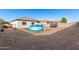 Spacious gravel backyard with an inflatable pool, swing set, and trampoline against a backdrop of block walls at 25913 W Cat Balue Dr, Buckeye, AZ 85396