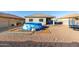 Backyard featuring an inflatable pool with chairs, a swing set, and a glimpse of the home's exterior at 25913 W Cat Balue Dr, Buckeye, AZ 85396