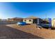 Gravel backyard with a blue inflatable pool, trampoline, and playset, surrounded by block walls and neighboring homes at 25913 W Cat Balue Dr, Buckeye, AZ 85396