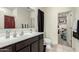 Bathroom featuring a large vanity with a white countertop, dark wood cabinets, and a walk in closet at 25913 W Cat Balue Dr, Buckeye, AZ 85396