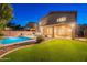 Expansive backyard featuring pool, covered patio, artificial grass, and desert landscaping at 26711 N 21St Dr, Phoenix, AZ 85085
