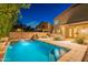 A private backyard pool is surrounded by a stone patio and desert landscaping for the ultimate retreat at 26711 N 21St Dr, Phoenix, AZ 85085