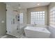 Inviting bathroom featuring soaking tub, glass enclosed shower, and modern finishes at 26711 N 21St Dr, Phoenix, AZ 85085
