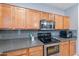 Modern kitchen featuring stainless steel appliances, wooden cabinets, and sleek countertops at 26711 N 21St Dr, Phoenix, AZ 85085
