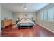 View of a comfortable bedroom with a ceiling fan and wood floors and bench seating at 26711 N 21St Dr, Phoenix, AZ 85085