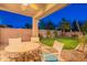 An outdoor patio with a round table and chairs overlooks a well-manicured backyard and privacy wall at 26711 N 21St Dr, Phoenix, AZ 85085