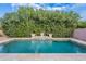 Inviting pool area with travertine tile and lush landscaping, perfect for relaxation and outdoor enjoyment at 26711 N 21St Dr, Phoenix, AZ 85085