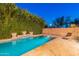 A tranquil pool with a brick surround, accent waterfall feature, and lush greenery for privacy at 26711 N 21St Dr, Phoenix, AZ 85085