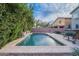 Backyard pool is surrounded by lush greenery and pavers, perfect for outdoor relaxation and entertaining at 26711 N 21St Dr, Phoenix, AZ 85085