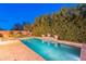 A stunning pool with cool blue water is surrounded by lush greenery and stylish brickwork at 26711 N 21St Dr, Phoenix, AZ 85085