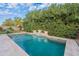 Inviting pool with waterfall feature, lush landscaping, and blue skies, perfect for relaxation and outdoor enjoyment at 26711 N 21St Dr, Phoenix, AZ 85085