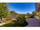 Green backyard featuring artificial turf, lush shrubs, and a wrought iron fence at 27248 W Mohawk Ln, Buckeye, AZ 85396