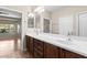 Bathroom featuring double sinks, wood cabinets, and a large mirror at 27248 W Mohawk Ln, Buckeye, AZ 85396