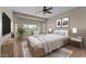 Relaxing bedroom featuring large windows, a ceiling fan, and a comfortable king-size bed at 27248 W Mohawk Ln, Buckeye, AZ 85396