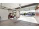 Open garage with overhead storage, a golf cart and neighborhood views beyond at 27248 W Mohawk Ln, Buckeye, AZ 85396