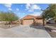 Three car garage with a low pitched tile roof and desert landscaping at 27248 W Mohawk Ln, Buckeye, AZ 85396