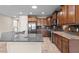 Modern kitchen featuring an island, stainless steel appliances, wood cabinets, and stone countertops at 27248 W Mohawk Ln, Buckeye, AZ 85396