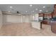 Spacious kitchen and living area featuring tile floors, kitchen island, wood cabinets, and a ceiling fan at 27248 W Mohawk Ln, Buckeye, AZ 85396