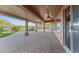 Expansive covered patio with brick pavers, ceiling fan, and view of the yard at 27248 W Mohawk Ln, Buckeye, AZ 85396