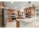 Spacious kitchen with stainless steel appliances, light wood cabinets, tile floors, and a breakfast bar at 3512 N Chambers Ct, Scottsdale, AZ 85251
