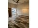 Living room with wood-look floors, modern lighting, and an open view of the renovated kitchen at 3646 N 67Th Ave # 83, Phoenix, AZ 85033