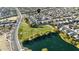 Scenic aerial view of a Primary-planned community with a green space and large pond at 41011 W Walker Way, Maricopa, AZ 85138