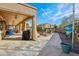 This covered patio features recessed lighting, shade curtains, and an outdoor kitchen area, perfect for entertaining at 41011 W Walker Way, Maricopa, AZ 85138