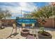 Backyard with large mural, seating around firepit, and desert landscaping at 41011 W Walker Way, Maricopa, AZ 85138