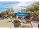 Charming backyard with mural, seating around firepit, and desert landscaping at 41011 W Walker Way, Maricopa, AZ 85138