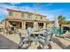 A tranquil backyard offers a covered patio, custom pool, lush tropical foliage, and an outdoor dining area at 41011 W Walker Way, Maricopa, AZ 85138