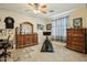 Well decorated bedroom with ceiling fan, dresser, and window with curtains at 41011 W Walker Way, Maricopa, AZ 85138