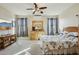 Bright bedroom with a large bed, dresser with mirror, mounted air conditioner and ample natural light at 41011 W Walker Way, Maricopa, AZ 85138