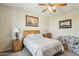 Comfortable bedroom featuring a floral bedspread, ceiling fan, and bedside table at 41011 W Walker Way, Maricopa, AZ 85138