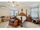 Spacious bedroom featuring wood frame bed, ceiling fan and bright natural light at 41011 W Walker Way, Maricopa, AZ 85138