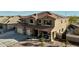 An impressive two-story home with a tile roof, three-car garage, and manicured desert landscaping at 41011 W Walker Way, Maricopa, AZ 85138