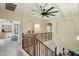 Upstairs hallway with dark wooden railings, visible decor niches, and a modern ceiling fan at 41011 W Walker Way, Maricopa, AZ 85138