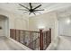 Upstairs hallway with dark wooden railings and neutral walls, creating a bright and airy atmosphere at 41011 W Walker Way, Maricopa, AZ 85138