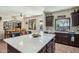 Bright kitchen with large island, granite countertops, dark cabinetry and stainless steel appliances at 41011 W Walker Way, Maricopa, AZ 85138
