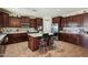 Modern kitchen with dark wood cabinets, stainless steel appliances and a center island with bar stool seating at 41011 W Walker Way, Maricopa, AZ 85138