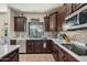 Beautiful kitchen featuring dark wood cabinets, stainless steel appliances and modern backsplash at 41011 W Walker Way, Maricopa, AZ 85138